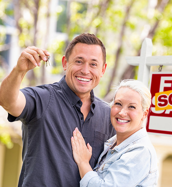 A man holding a key to a house from the Best Loans company in Irvine.