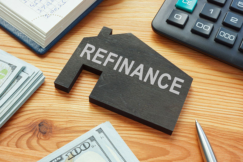 A wooden house with the word refinance written on it.